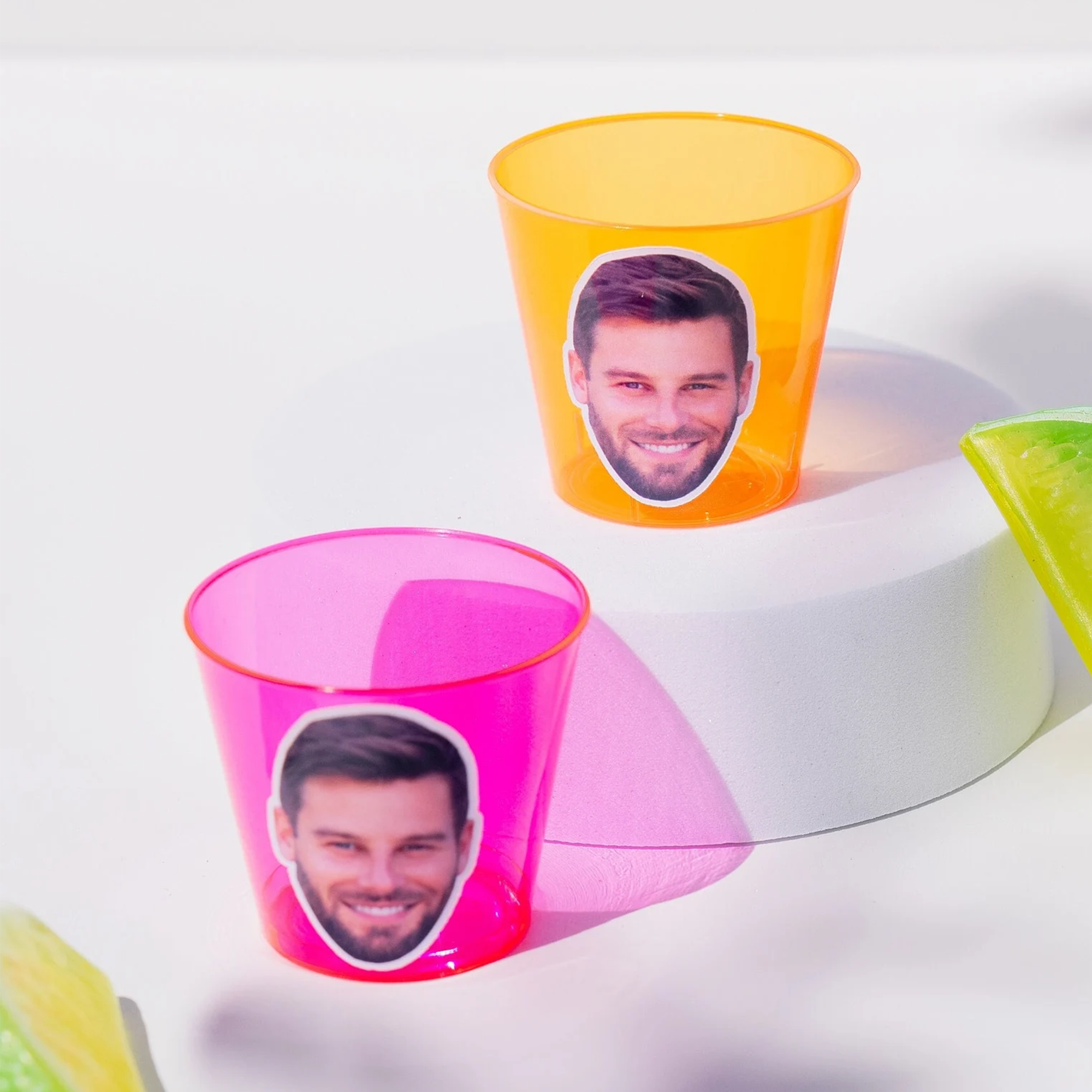 Two custom pink and orange plastic shot cups with a mans face on the front. Send a picture to personalize.