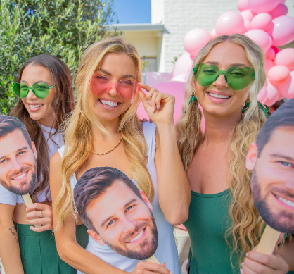 Girls at a bachelorette party holding the groom's face on a stick from Sunkissed Party Co.