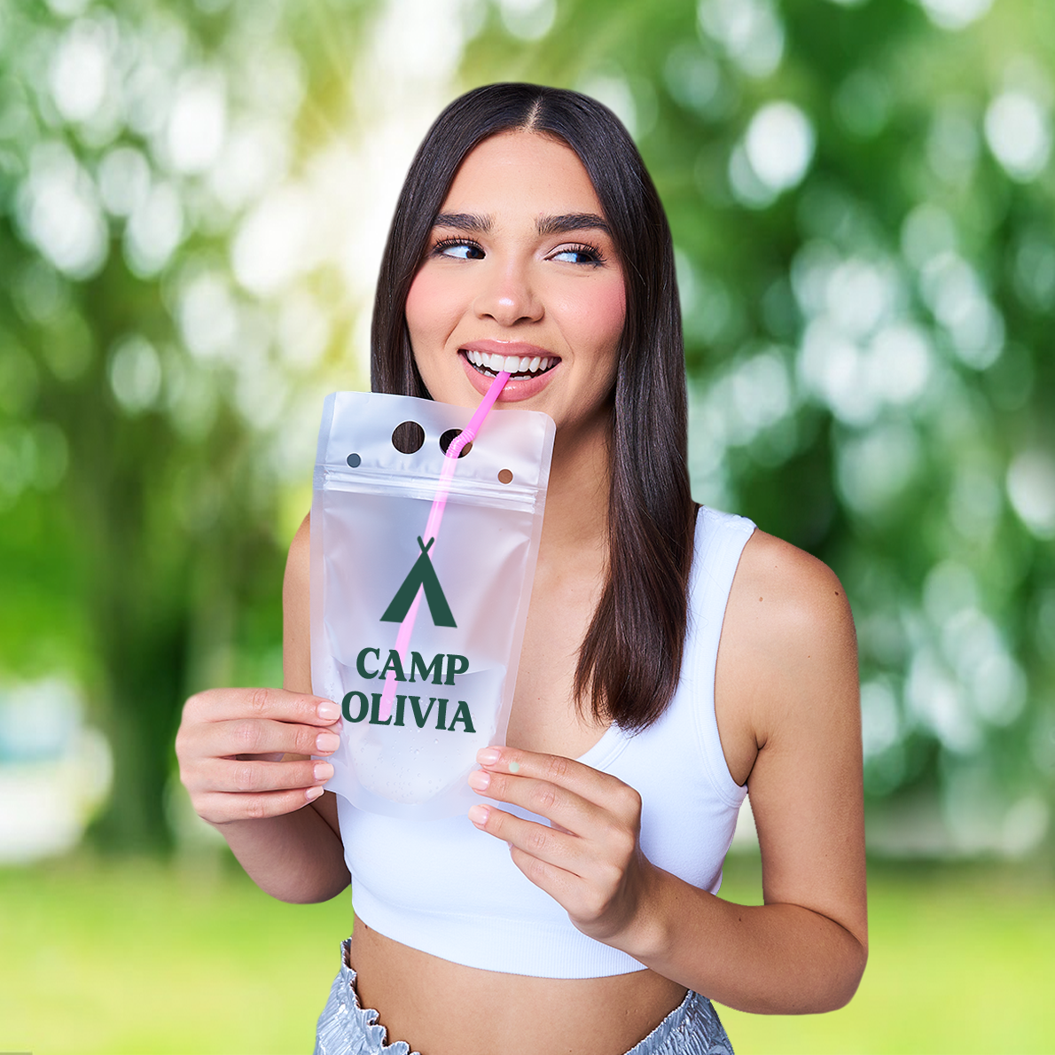 Bride at camp-themed bachelorette party holding personalized cocktail drink pouch with her name used as a custom party favor.