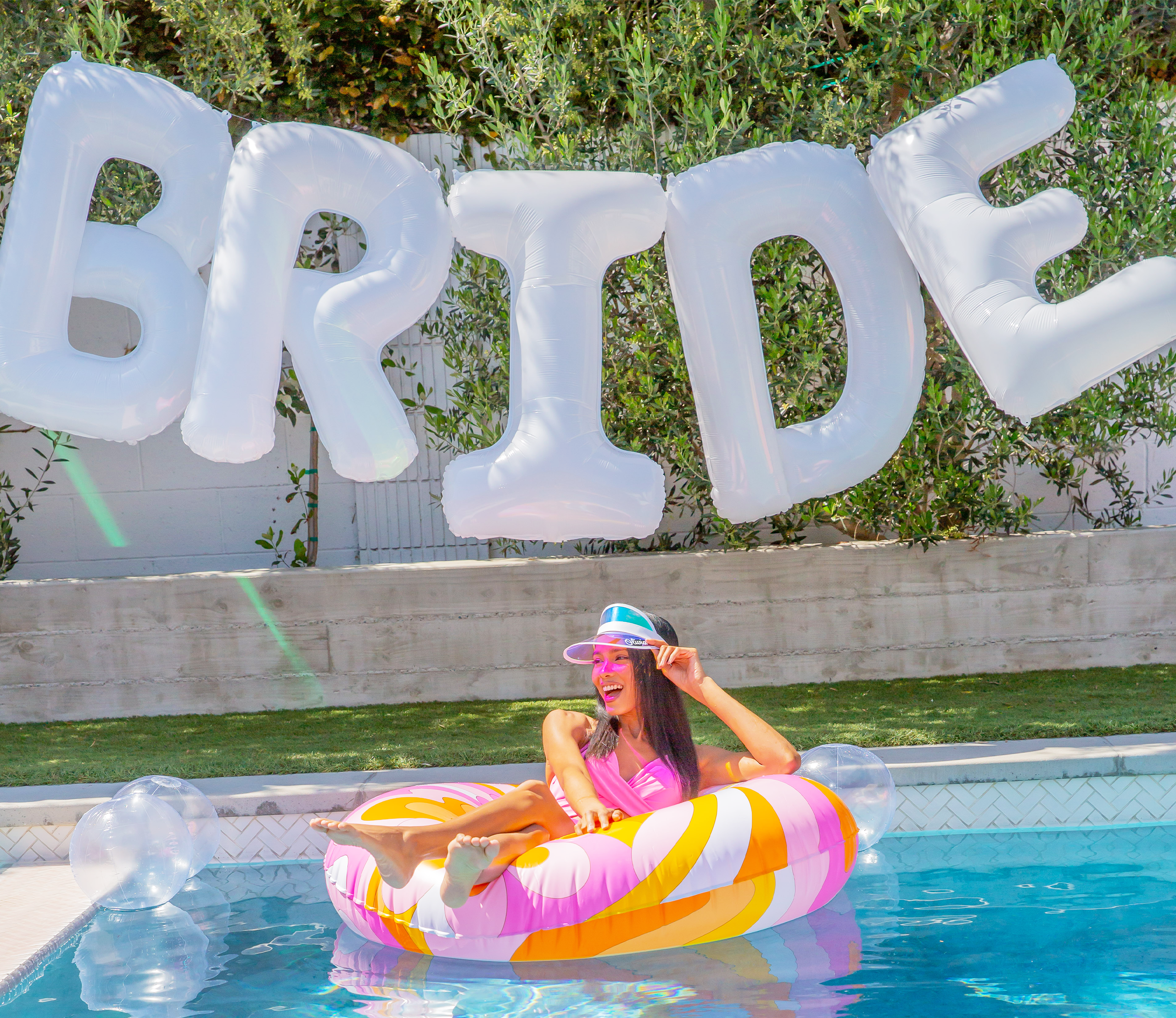 Bride at bachelorette party with a jumbo white bride balloon hanging for party decorations